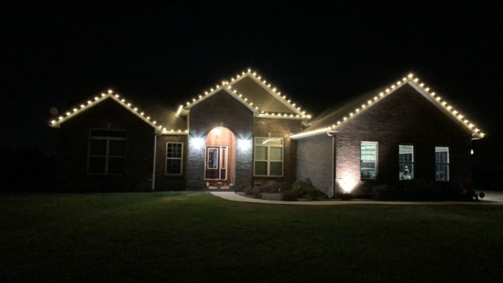 Warm white Christmas lights outlining a home at night